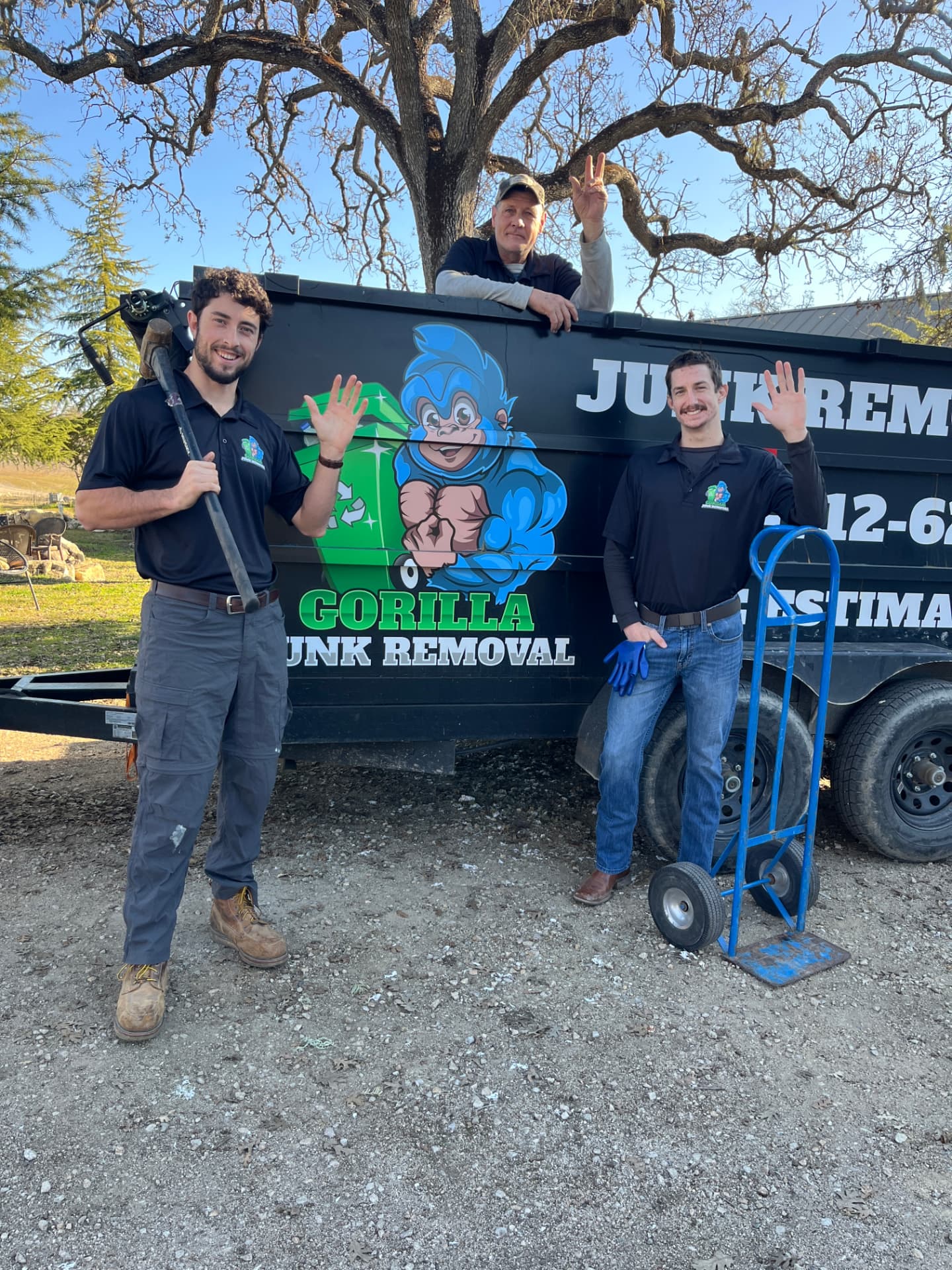Junk Hustlers University crew in front of a loaded junk removal trailer